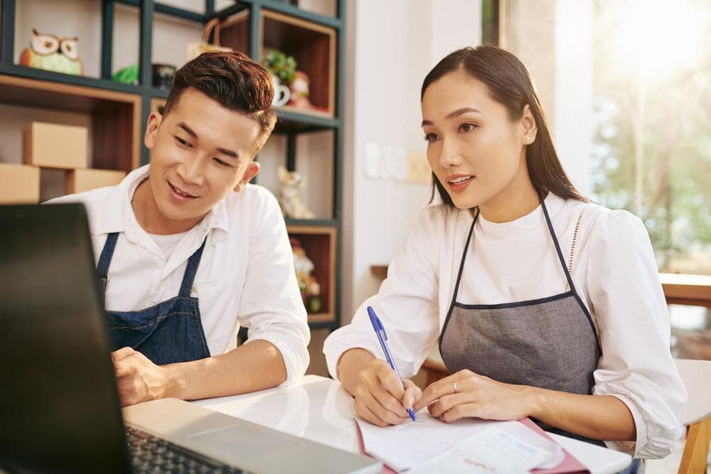 คู่สามีภรรยากำลังลิสต์ว่าถ้าอยากเปิดร้านอาหารต้องทำอะไรบ้าง